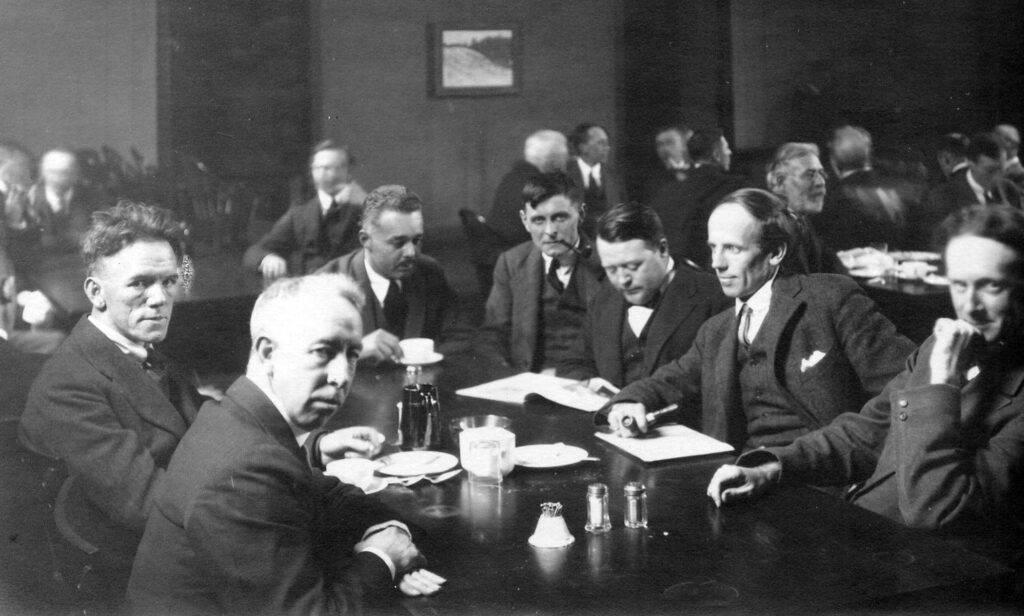 Group of Seven: From left to right: Frederick Varley, A. Y. Jackson, Lawren Harris, Barker Fairley (not a member), Frank Johnston, Arthur Lismer, and J. E. H. MacDonald. Photograph by Arthur Goss, ca. 1920, Archives of Ontario, Toronto, Canada.
