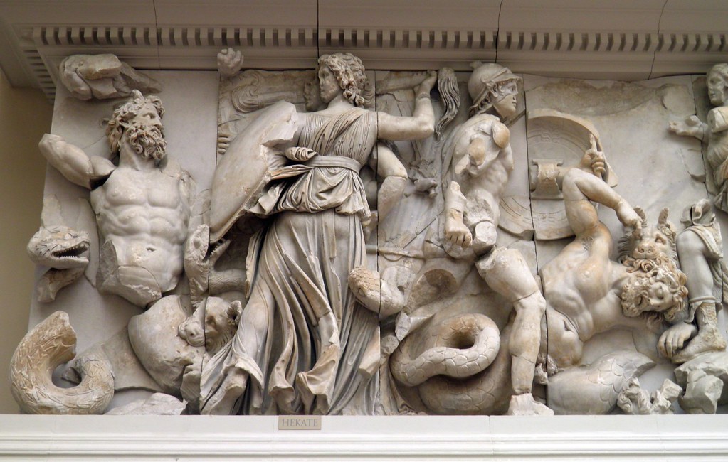 Hecate art: Scene of the Gigantomachy, Hecate depicted in her triple form, fighting with a torch, a sword, and a lance, east frieze of the Pergamon Altar, 2nd c. BCE, Pergamon Museum, Berlin, Germany.
